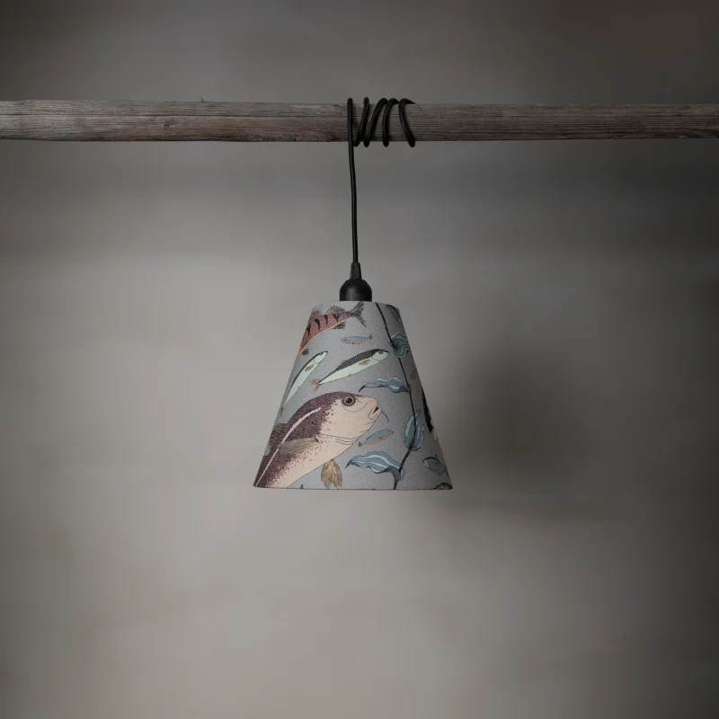 Lampskärm i linneblandning med ett mönster av fiskar, tillverkad av NORDRÅ Sweden som säljer presenter och inredning.