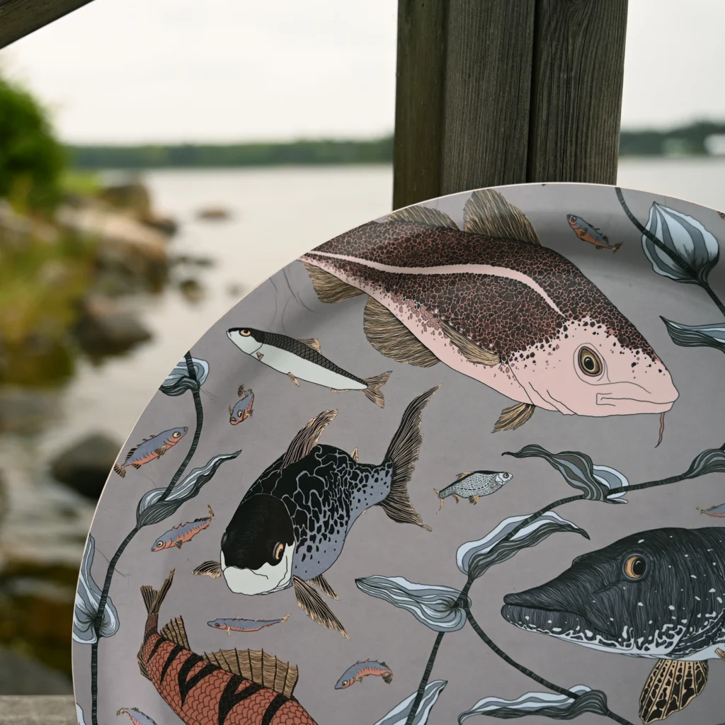 Grå bricka med fiskar med unik mönsterdesign från NORDRÅ Sweden som säljer presenter och inredning.