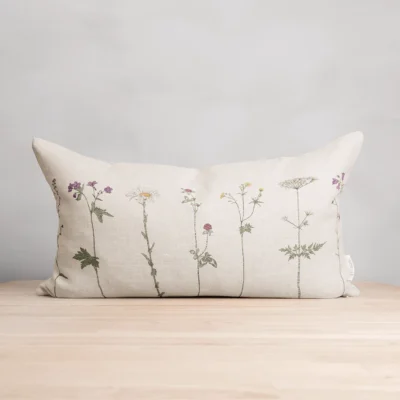 Beige kudde i 100 % linne med blommor som mönster, tillverkad av NORDRÅ Sweden som säljer presenter och inredning.